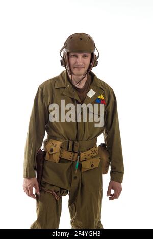 L'homme acteur habille ou enlève l'uniforme militaire d'un Tankman américain de la période de la Seconde Guerre mondiale pose sur fond blanc Banque D'Images