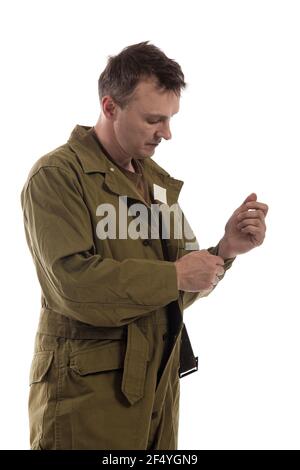 L'homme acteur habille ou enlève l'uniforme militaire d'un Tankman américain de la période de la Seconde Guerre mondiale pose sur fond blanc Banque D'Images