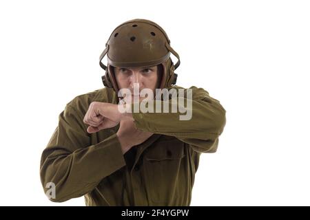 L'homme acteur habille ou enlève l'uniforme militaire d'un Tankman américain de la période de la Seconde Guerre mondiale pose sur fond blanc Banque D'Images