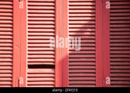 Volets en bois. Volets de fenêtre fermés, anciens, de couleur rouge rétro pour l'arrière-plan, la texture. Structure traditionnelle en bois abîmé par temps ensoleillé, Banque D'Images