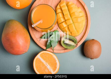 Verre de jus d'orange et de mangue et tranche d'orange fruits sur un bureau en bois Banque D'Images