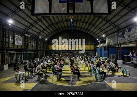 Les dévotés catholiques assistent à une messe en soirée le mercredi des cendres dans un tribunal couvert de la ville de Quezon. Des millions de dévotés philippins se sont emmenés dans les églises de tout le pays pour observer le début de la saison de Lenten malgré les restrictions causées par la COVID-19. La Conférence des évêques catholiques des Philippines (CBCP) a recommandé de mettre des cendres sur les chefs de dévots pour maintenir une distanciation physique au milieu de la nouvelle pandémie du coronavirus. Philippines. Banque D'Images