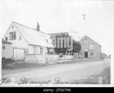 Akureyri (Islande). Hauptstraße (non pavée) avec des bâtiments résidentiels et commerciaux et le seul arbre du village (Ebersche) Banque D'Images