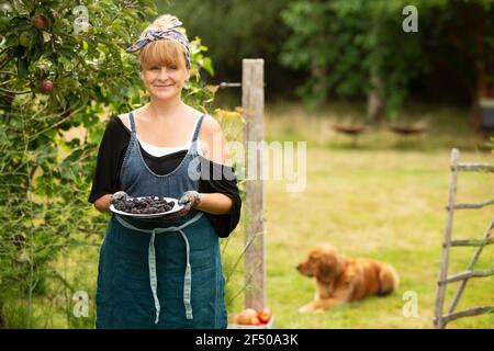 Portrait fière femme avec des mûres dans le jardin d'été Banque D'Images