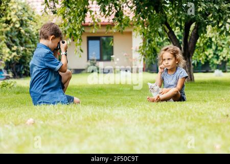 The kids with a kitten are photographed in the backyard Stock Photo