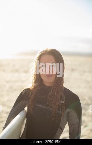 Portrait belle jeune femme surfeuse avec cheveux mouillés sur le soleil plage Banque D'Images