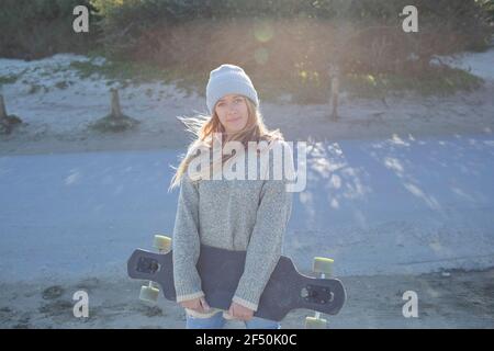 Portrait belle jeune femme avec skateboard Banque D'Images
