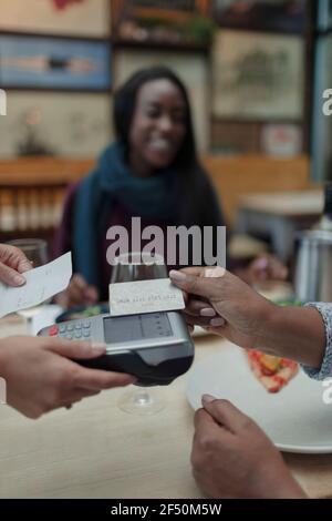 Gros plan sur une serveuse payante avec carte à puce au café tableau Banque D'Images