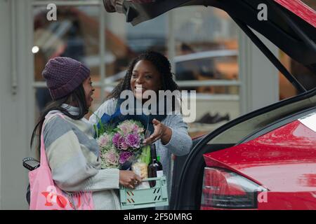 La mère et la fille chargent les produits d'épicerie à l'arrière de la voiture magasin extérieur Banque D'Images