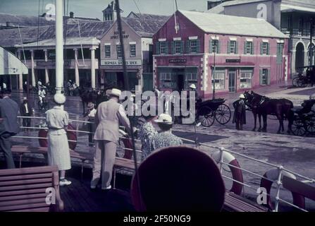 Photos de voyage Bermudes. Hamilton, voyageurs sur le pont d'un navire à passagers. Vue sur le quai avec « The Bermuda Sport Shop » et « John A. P. Pitt & Co Banque D'Images