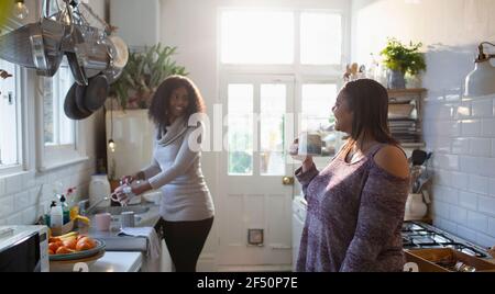 Mère et fille faisant des plats et prenant le thé dans la cuisine Banque D'Images
