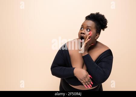 une femme afro-américaine de grande taille qui se prend à l'écart, a été surprise beige Banque D'Images