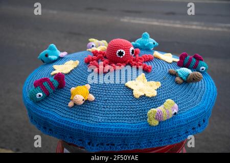 Rouge, boîte postale, boîte postale, crochetée, Royal Mail, Chapeaux en laine, housses, tricotés à la main, boîtes à colonnes, Lincoln City, Créatures marines, lapins de Pâques, fleurs. Banque D'Images