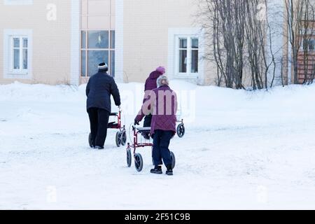 Umea, Norrland Suède - 4 mars 2021 : les femmes plus âgées sont dehors avec leurs marchettes dans la neige Banque D'Images