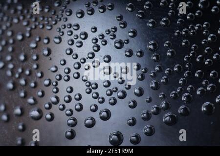 Bulles d'air dans l'eau. Bulles métalliques transparentes sur fond sombre. Soda en gros plan. Banque D'Images