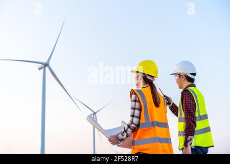 une équipe de jeunes ingénieurs analyse un schéma de l'éolienne ferme Banque D'Images