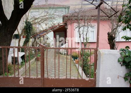 La vieille maison rose est dans les derniers jours de l'hiver. Les arbres sont encore secs. Avec deux étages et un jardin. Banque D'Images