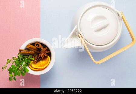 Tisane sur fond pascal rose et bleu - thymienne cannelle citron orange anis vue de dessus ou plat Banque D'Images