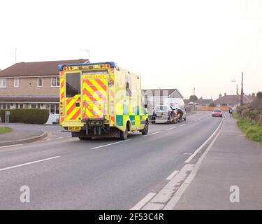 2021 mars - UK Amublance attendant de passer une voiture avec parrked dans le village Somerset de Cheddar. Banque D'Images