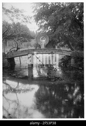 Japon. Une femme japonaise avec un écran à motif de trèfle se dresse sur un énorme pont d'arc Banque D'Images