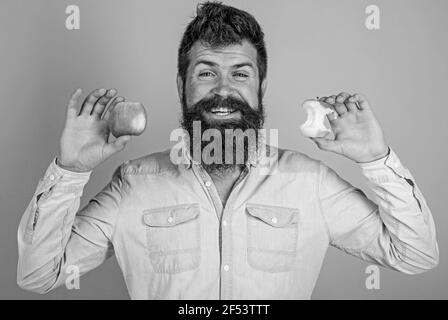 Mangez de la pomme tous les jours. Fruits en-cas sain toujours bonne idée. La belle barbe hipster longue de l'homme tient la pomme mûre et la souche de pomme presque mangée. Parfait et Banque D'Images