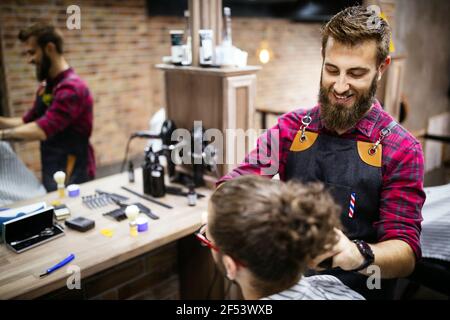 Coiffure rasage un homme barbu dans une boutique de coiffeur, close-up Banque D'Images