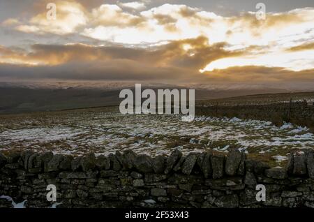 Un mur de pierre sec avec des collines couvertes de neige au-delà à Weardale, les Pennines du Nord, comté de Durham, Royaume-Uni Banque D'Images