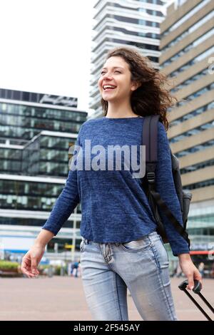 Portrait d'une jeune femme joyeuse souriant avec ses bagages à l'aéroport Banque D'Images