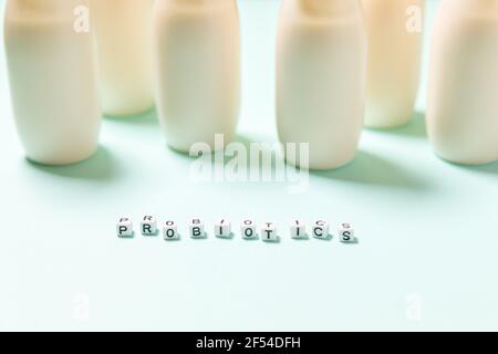 Petits flacons avec probiotiques et prébiotiques boisson laitière sur fond bleu. Production avec des additifs biologiquement actifs. Fermentation et régime guérir Banque D'Images