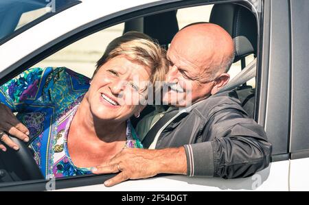 Un couple senior heureux qui s'amuse en voiture sur le Route - concept joyeux et actif de personnes âgées avec l'homme à la retraite et femme appréciant les meilleures années Banque D'Images