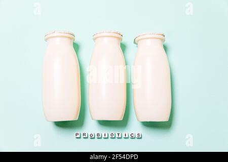 Petits flacons avec probiotiques et prébiotiques boisson laitière sur fond bleu. Production avec des additifs biologiquement actifs. Fermentation et régime guérir Banque D'Images