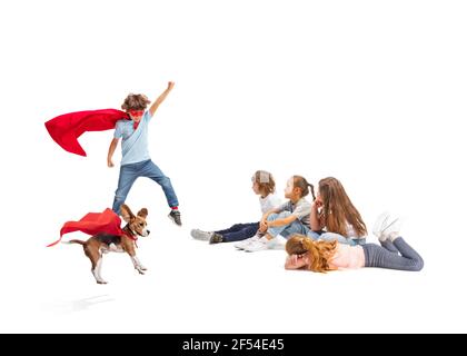 Enfant prétendant être un super-héros avec son super chien et des amis assis autour Banque D'Images