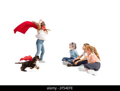 Enfant prétendant être un super-héros avec son super chien et des amis assis autour Banque D'Images