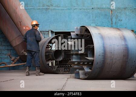 Aksu, région de Pavlodar, Kazakhstan - mai 29 2012 : travailleur avec des pièces du nouveau système de ventilation de l'usine métallurgique. Banque D'Images