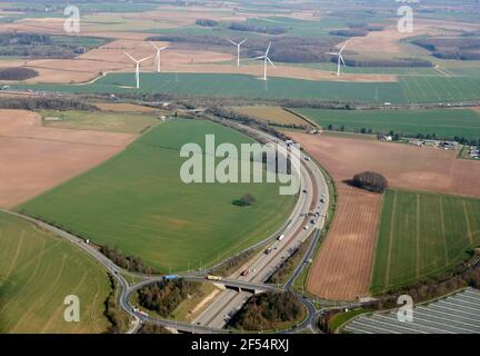 Une vue aérienne de l'extrémité de l'autoroute /M1 où elle rejoint l'A1 en direction du nord, à Aberford, West Yorkshire, Northern England, Wind turbines lointaines Banque D'Images