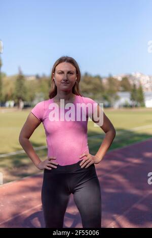 Une belle femme, avec un corps bien entretenu dans une ligne parfaite, pose pour un photographe dans un stade de près Banque D'Images