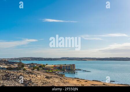 L'hôtel Luederitz Nest donne sur une mer tranquille sur le terrain accidenté et rocailleux de Luderitz, en Namibie. Fond bleu ciel Banque D'Images