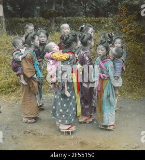 Japon. Des filles et des femmes japonaises dans un kimono avec des tout-petits sur le dos Banque D'Images