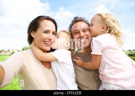 Portrait d'une jeune femme heureuse parlant selfie de sa famille à l'extérieur Banque D'Images