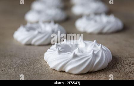 Nids de meringue vides, fond de pierre clair. Concept pour un délicieux dessert sucré. Mise au point sélective. Banque D'Images