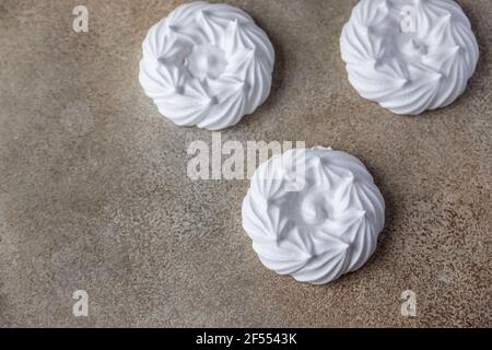 Nids de meringue vides, fond de pierre clair. Concept pour un délicieux dessert sucré. Mise au point sélective. Banque D'Images