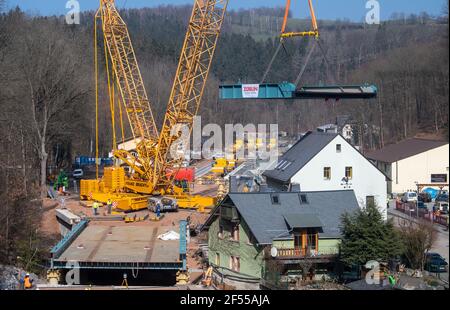 Amtsberg, Allemagne. 24 mars 2021. Une grue est utilisée pour soulever une section pour un pont ferroviaire au-dessus de la rivière Zwönitz dans la voie. La structure pèse au total 180 tonnes, mesure 37 mètres de long, 11 mètres de large et est placée sur les butées en deux sections distinctes. Le pont fait partie de la ligne de chemin de fer entre Aue et la gare centrale de Chemnitz. Selon le Verkehrsverbund Mittelsachsen (VMS), une date d'achèvement n'a pas encore été fixée en raison des conditions de corona. Credit: Hendrik Schmidt/dpa-Zentralbild/ZB/dpa/Alay Live News Banque D'Images