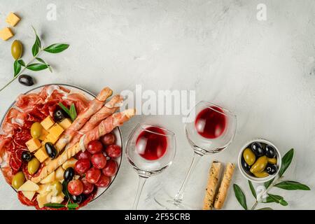 Encas avec vin sur fond gris. Au-dessus de la tête, espace de photocopie. Banque D'Images