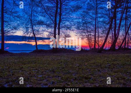 Paysage du début du printemps avec coucher de soleil sur le lac Banque D'Images