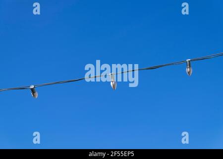 Un détail, un regard abstrait sur une corde, un brin de vacances, des lumières de Noël contre un ciel bleu. À Dillon Beach, Californie. Banque D'Images