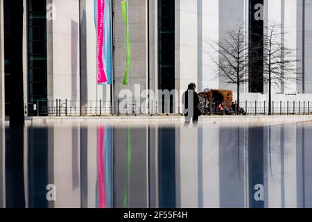 Berlin, Allemagne. 24 mars 2021. Une personne marche à travers le quartier du gouvernement, avec le paysage reflété dans une dalle de pierre. Credit: Christoph Soeder/dpa/Alay Live News Banque D'Images
