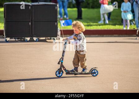 DOMZALE, SLOVÉNIE - 21 juin 2019 : petit garçon, tout-petit scooter de randonnée Banque D'Images