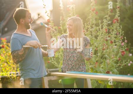 Femme blonde faisant malin avec petit ami dans le jardin Banque D'Images