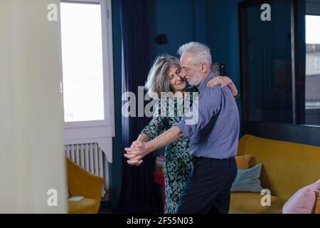 Couple senior dansant debout à la maison Banque D'Images