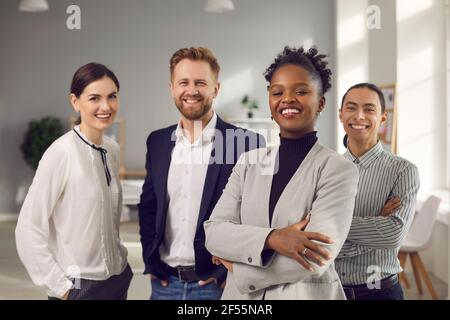 Portrait d'une jeune équipe multiraciale positive posant au bureau en regardant la caméra. Banque D'Images